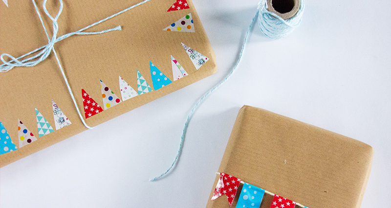 Gifts packed in grey paper, decorated with colourful christmas trees.