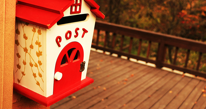 Poštovní schránka ve tvaru domečku.
