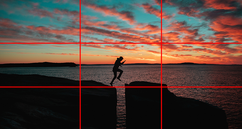 Man jumping over the rocks, horizon in the background