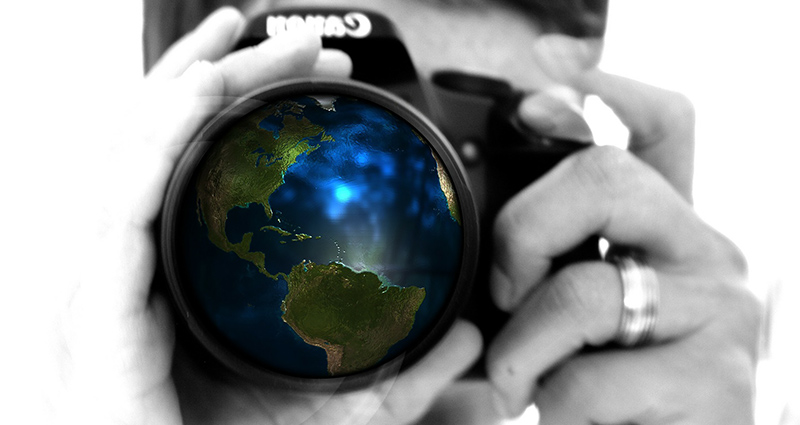 Man taking a picture, a lens in a form of a globe in the centre of the frame