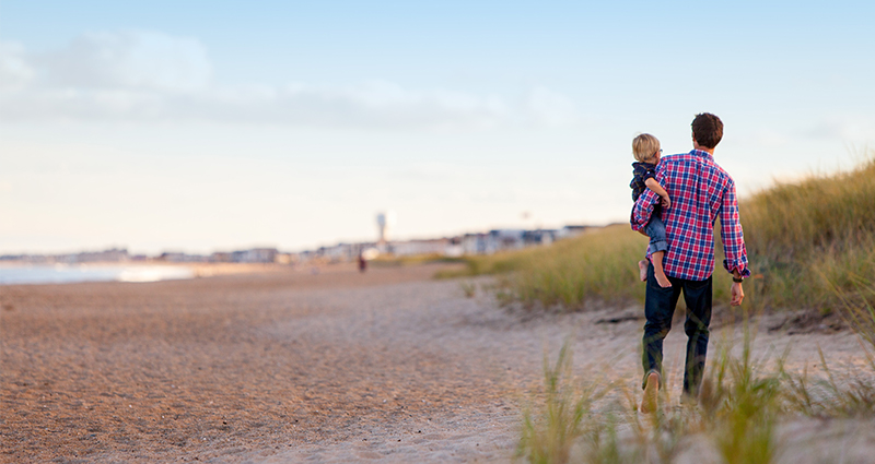 Padre con figlia che cammina sulla spiaggia