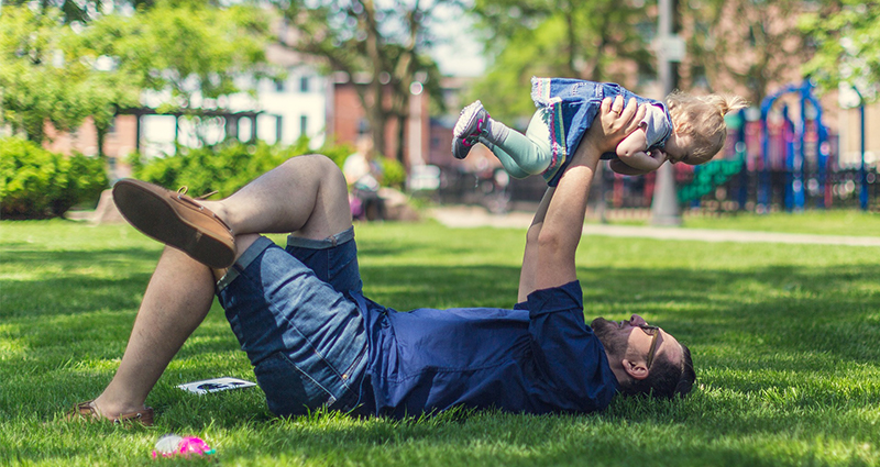 Vater spielt mit kleiner Tochter im Park 