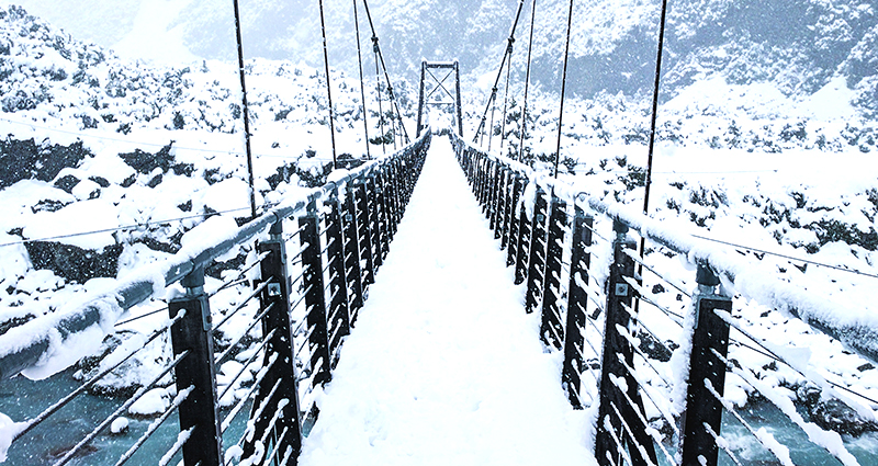 La foto del puente con las montañas en el fondo.