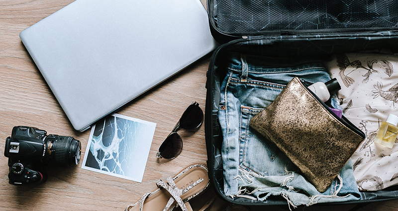 Une valise ouverte et les choses à prendre en voyage.