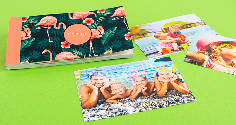  Un sharebook avec la couverture Flamingo, à coté des photos de vacances detachées.