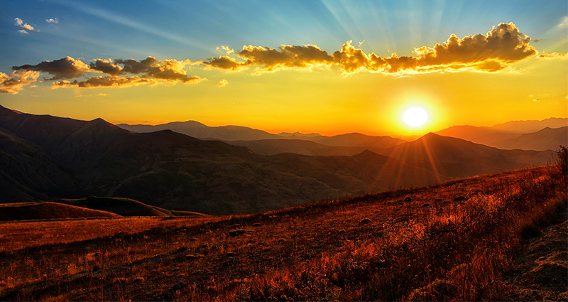 Tramonto in montagna, foto in tonalità blu, arancione, giallo.