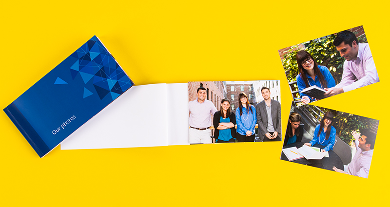 Two sharebooks, one open lying next to a sharebook with the Abstract Art cover, photos of university students on the right side.