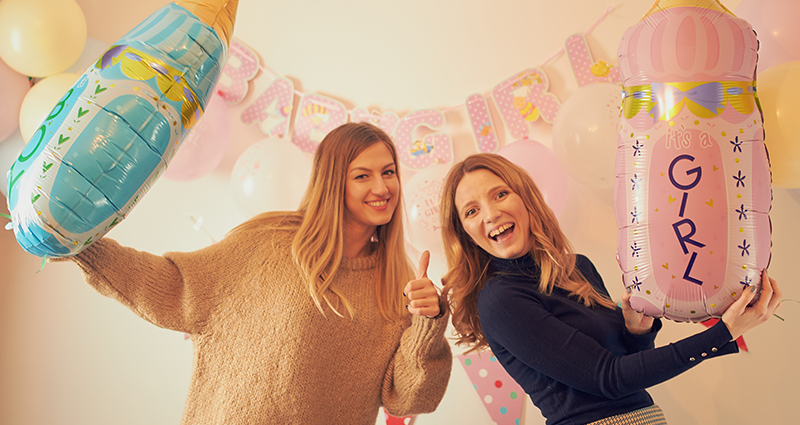 Two women with bottle-shaped balloons