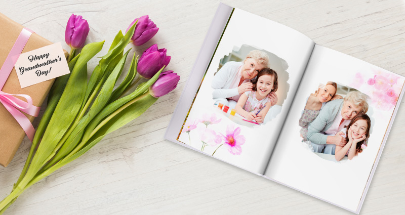 Un livre photo ouvert avec des photos de grand-mère avec ses petits enfants, à côté  des tulipes roses et un cadeau emballé.