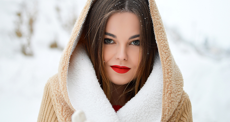 Una mujer con capucha con los labios rojos.