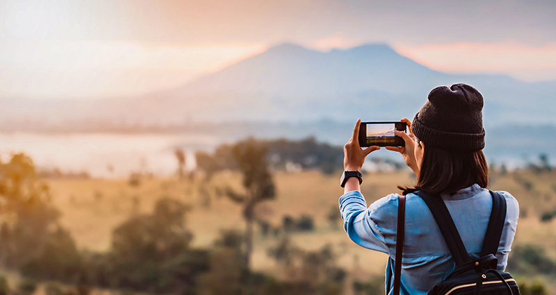 Una mujer tomando una foto mientras está de viaje