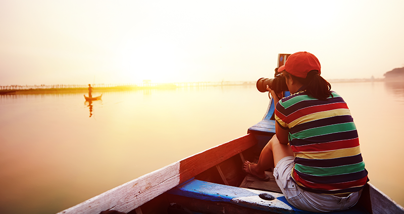 Woman taking picture during golden hour using travel photography tips and techniques