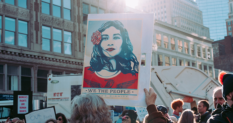 Frauentag – Demonstranten halten ein Poster mit Frauengesicht hoch
