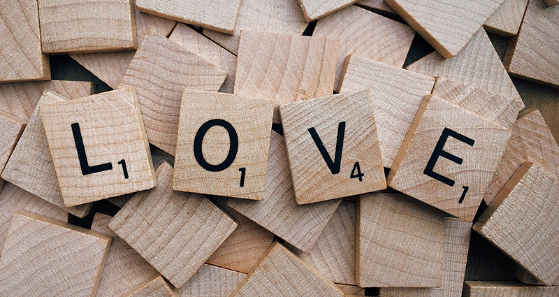 Užrašas "LOVE" iš scrabble kaladėlių.