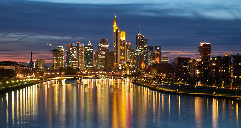 City lights at night reflected in the bay water.