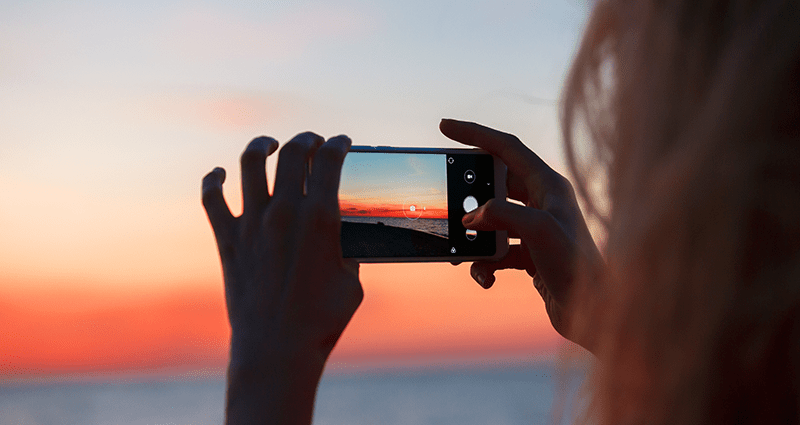 Žena při fotografování krajiny pomocí tipů pro fotografování krajiny na pláži