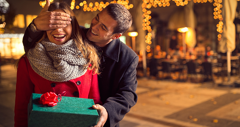 Un hombre joven le hace una sorpresa a su novia con regalo personalizado