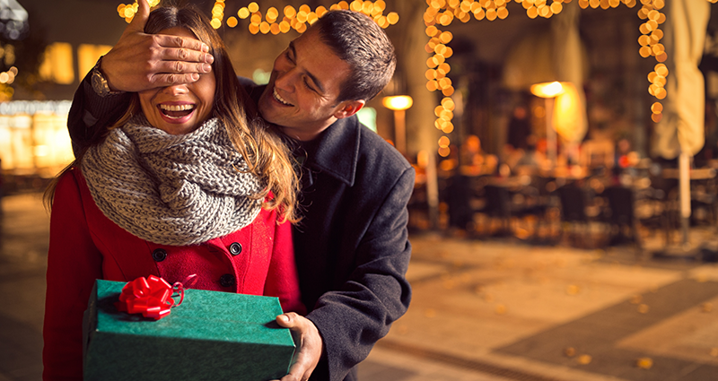 Ein junger Mann macht einer Frau eine Überraschung. Personalisierte Valentinsgeschenke