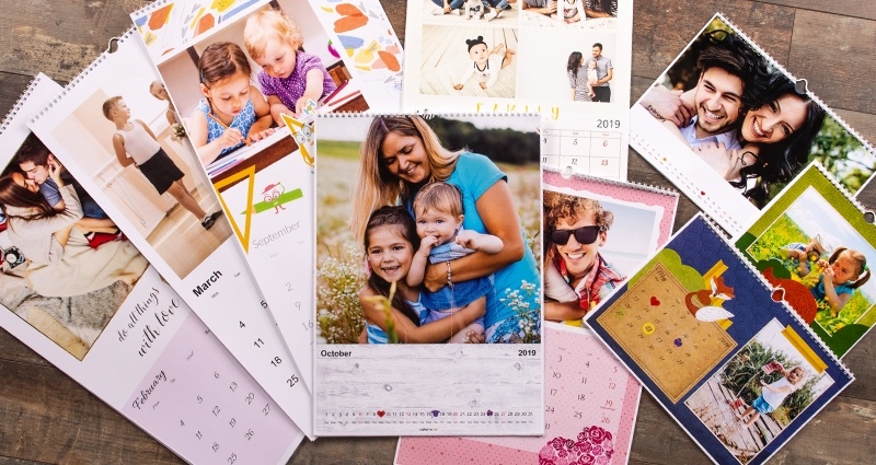 Colorland Fotokalender (verschiedene Formate) liegen auf einem Holzfußboden.