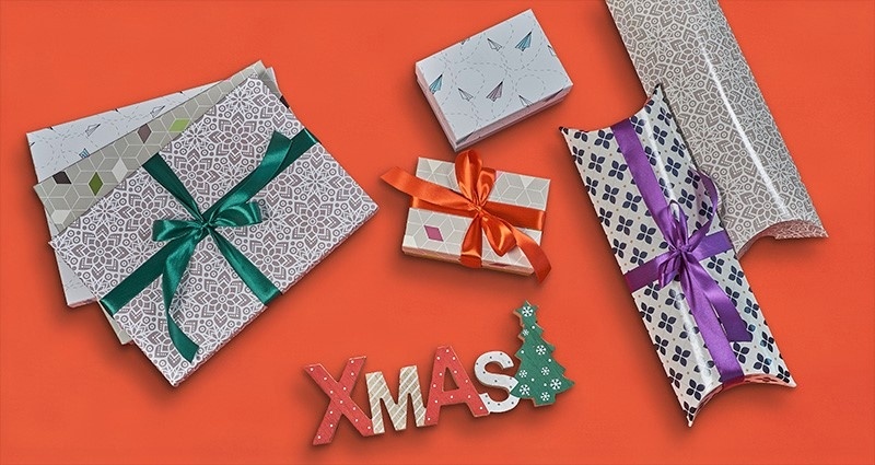 Gift boxes for photobooks, prints and photo calendars on the red background; decorative wooden letters XMAS below them.
