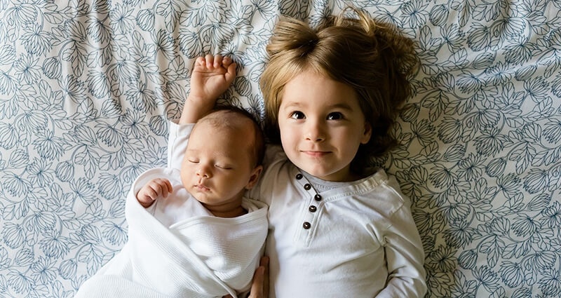 Dos hermanos acostándose en la cama.