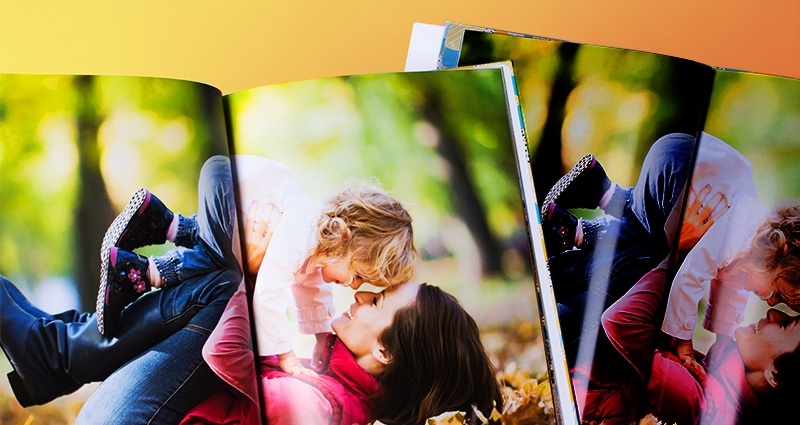 Due fotolibri aperti. Un libro stampato nella tecnologia 7C, il secondo in modo tradizionale sulla stampante tipo XEROX. Libri con immagini che mostrano una mamma che gioca con sua figlia in uno scenario autunnale.